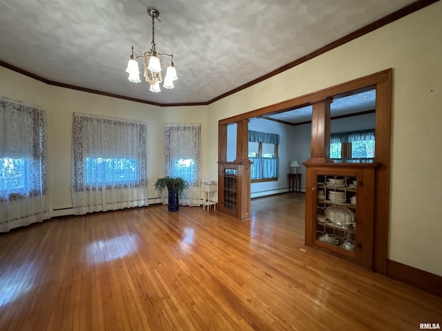 323 E Cortland St, Avon, IL 61415 - unfurnished room featuring a chandelier, hardwood / wood-style floors, crown molding, and baseboard heating