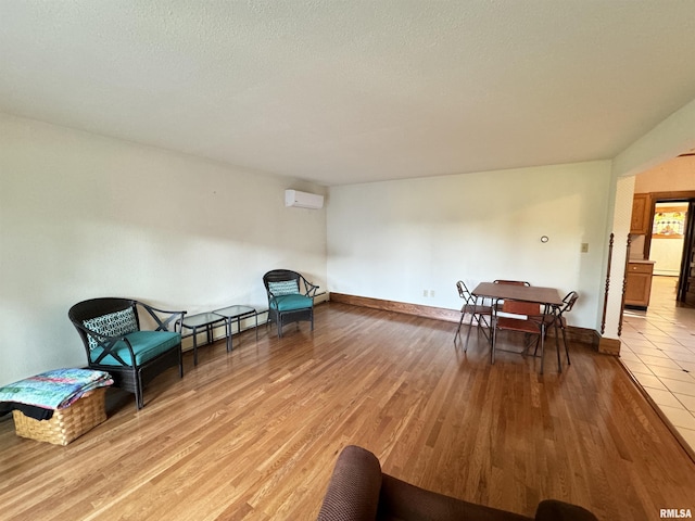 323 E Cortland St, Avon, IL 61415 - sitting room featuring light wood-type flooring, baseboards, and a wall mounted AC