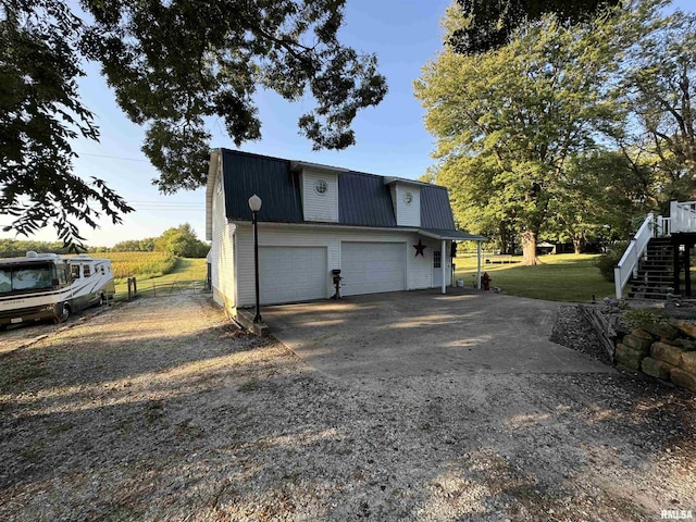 323 E Cortland St, Avon, IL 61415 - view of side of home with metal roof, concrete driveway, a garage, a gambrel roof, and stairway