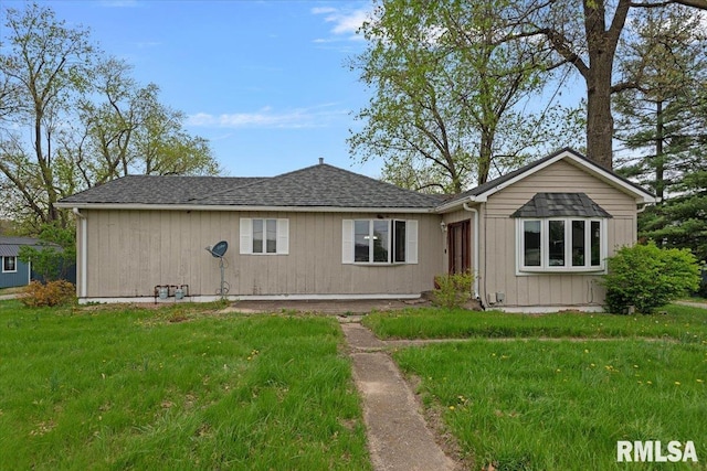 view of front of house with a shingled roof and a front yard