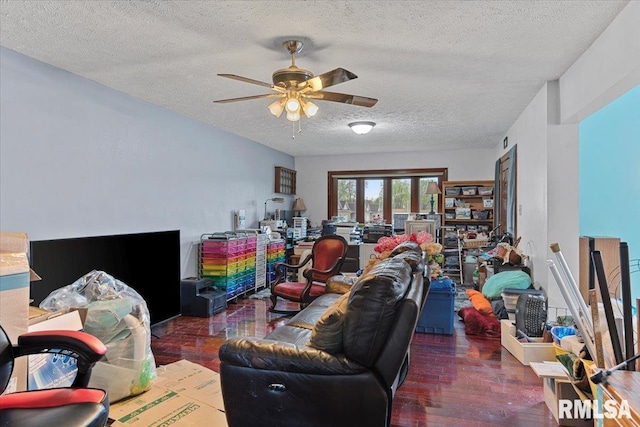 living room with ceiling fan, wood finished floors, and a textured ceiling