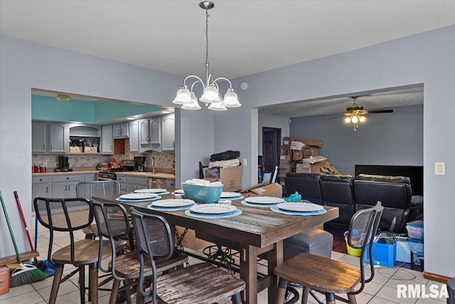 dining room featuring light tile patterned flooring and ceiling fan with notable chandelier