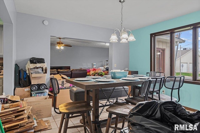 dining space featuring light tile patterned floors and ceiling fan with notable chandelier