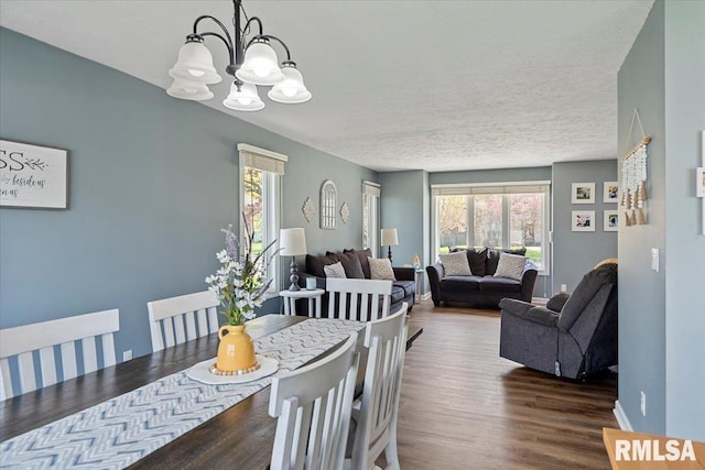dining space with a notable chandelier, wood finished floors, and plenty of natural light