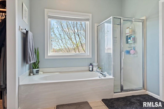 bathroom featuring a shower stall, a bath, and tile patterned floors