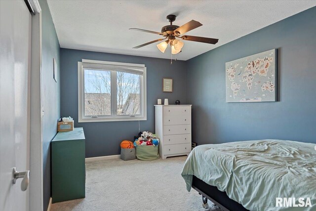 carpeted bedroom featuring baseboards and ceiling fan