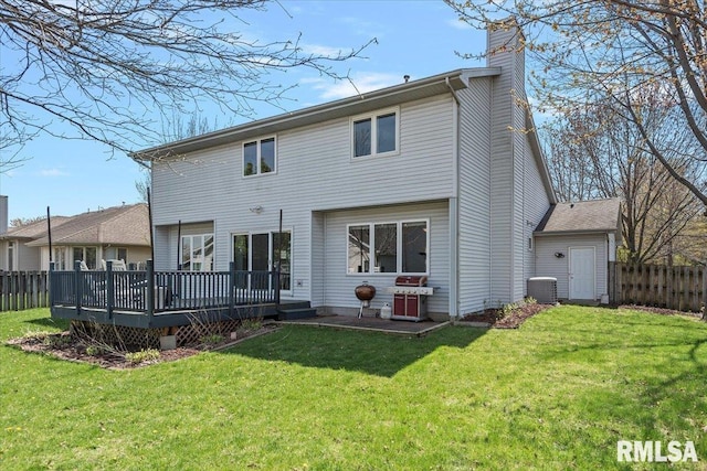 back of property featuring a yard, fence, and a deck