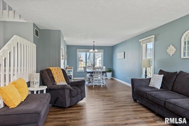 living area with dark wood-type flooring, visible vents, a wealth of natural light, and a chandelier
