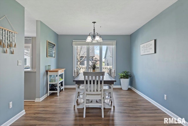 dining area with a wealth of natural light, dark wood-style flooring, a chandelier, and baseboards