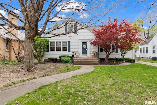 view of front of house with a front yard and cooling unit