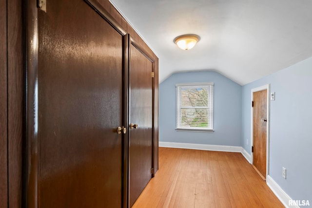 additional living space featuring lofted ceiling, baseboards, and light wood finished floors