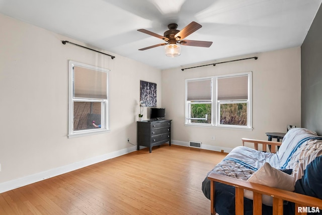sitting room with visible vents, a ceiling fan, baseboards, and light wood-style floors