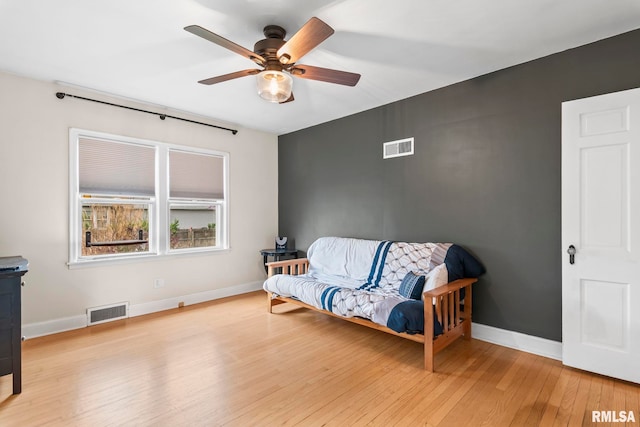 living area featuring ceiling fan, baseboards, hardwood / wood-style floors, and visible vents