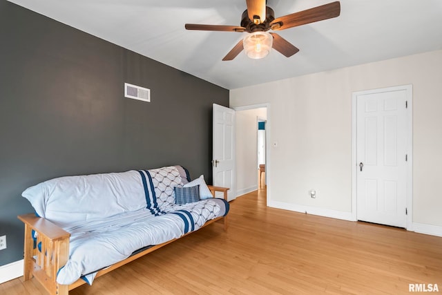 sitting room with baseboards, a ceiling fan, light wood-style floors, and visible vents