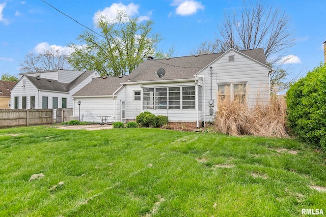 back of house with a lawn, a shingled roof, a patio, and fence