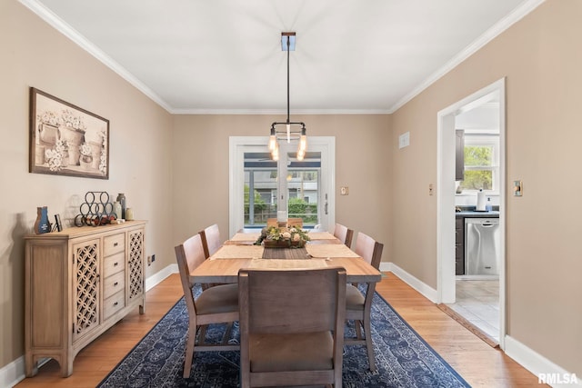 dining space with baseboards, ornamental molding, and light wood-style floors