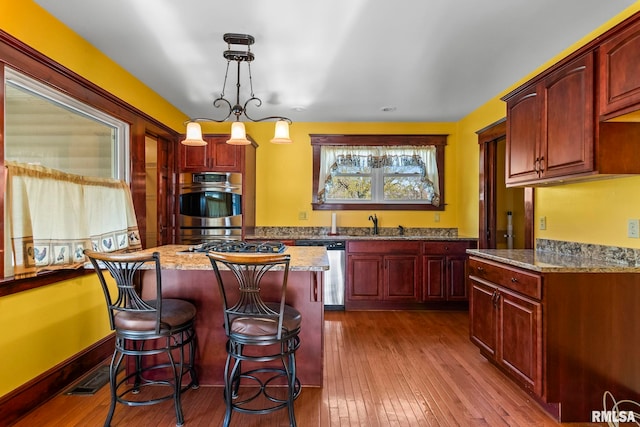 101 E Lester St, Williamsville, IL 62693 - kitchen featuring dark brown cabinets, appliances with stainless steel finishes, and light stone counters