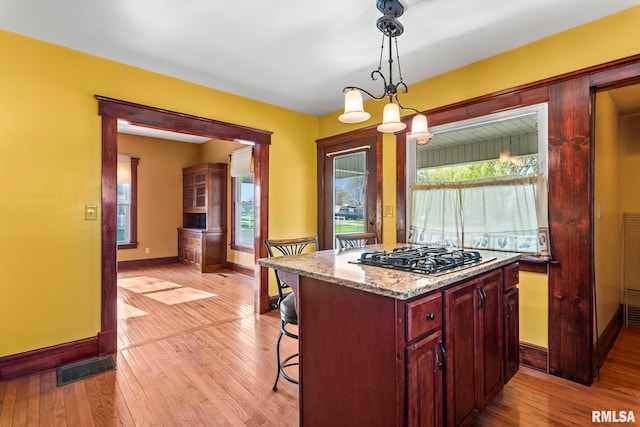 101 E Lester St, Williamsville, IL 62693 - kitchen featuring dark brown cabinets, stainless steel gas cooktop, light wood-style floors, baseboards, and visible vents