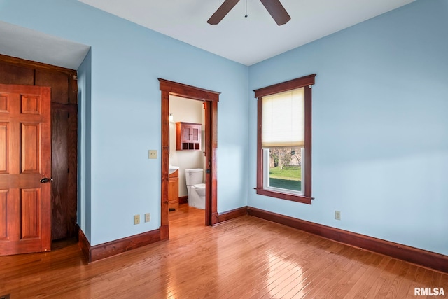 101 E Lester St, Williamsville, IL 62693 - unfurnished bedroom featuring light wood-type flooring, ensuite bath, and baseboards