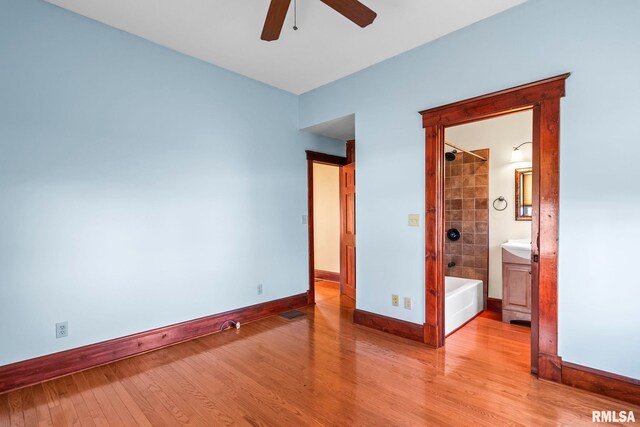 101 E Lester St, Williamsville, IL 62693 - unfurnished bedroom featuring connected bathroom, baseboards, light wood-style floors, and visible vents