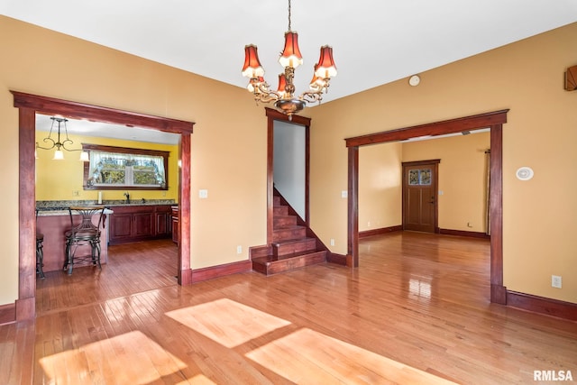 101 E Lester St, Williamsville, IL 62693 - interior space with light wood finished floors, an inviting chandelier, baseboards, and a sink