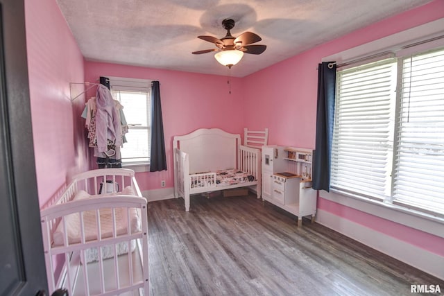 bedroom featuring baseboards, wood finished floors, and ceiling fan