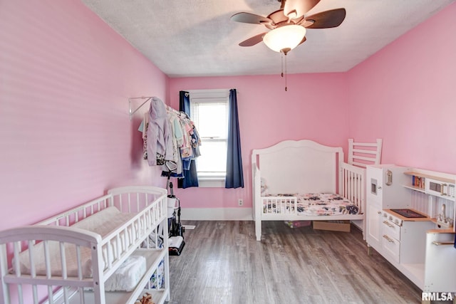 bedroom with baseboards, a ceiling fan, and wood finished floors