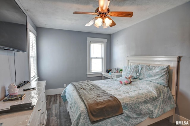bedroom featuring baseboards, dark wood-type flooring, and ceiling fan