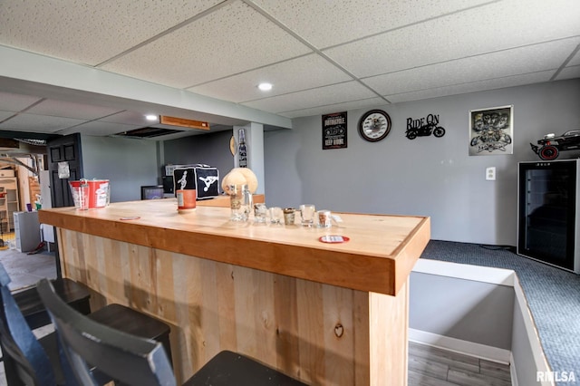 interior space featuring beverage cooler and a paneled ceiling