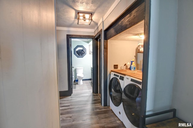 washroom with a textured ceiling, dark wood-style floors, washer and dryer, and laundry area
