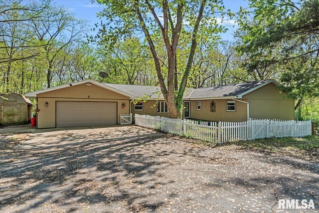 view of front of house with an outdoor structure, a fenced front yard, dirt driveway, a shed, and an attached garage