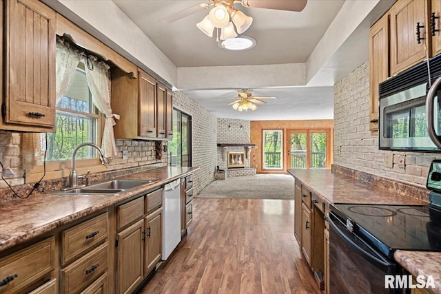 kitchen featuring stainless steel microwave, dishwasher, a sink, black range with electric cooktop, and a ceiling fan