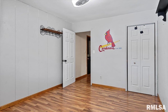 unfurnished bedroom with baseboards and wood finished floors
