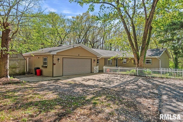 single story home featuring a fenced front yard, dirt driveway, and an attached garage