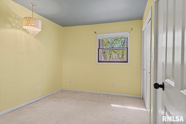 unfurnished room with carpet floors, visible vents, and baseboards