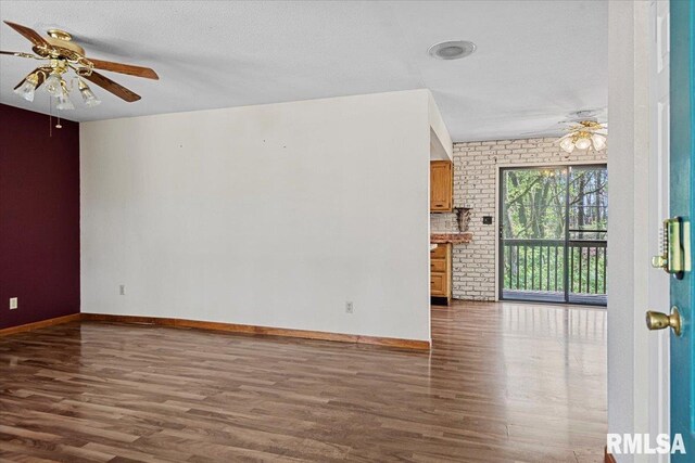 unfurnished living room featuring baseboards, wood finished floors, and a ceiling fan