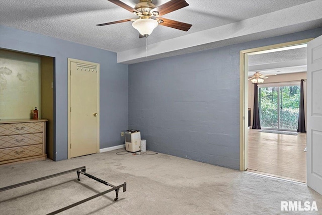 unfurnished bedroom with a textured ceiling, ceiling fan, and carpet flooring