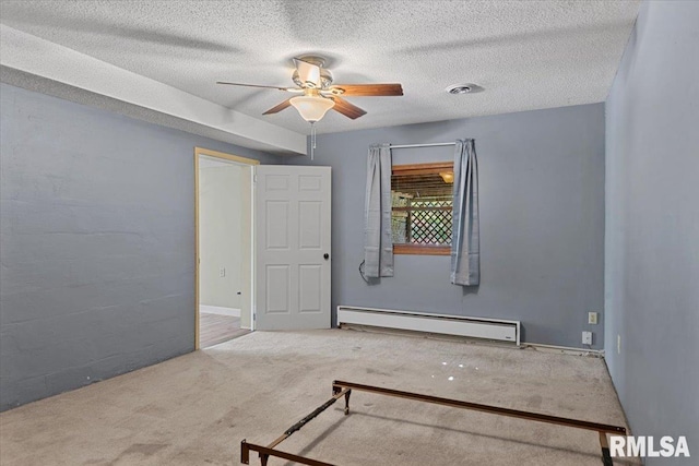 carpeted spare room with a textured ceiling, ceiling fan, visible vents, and a baseboard heating unit