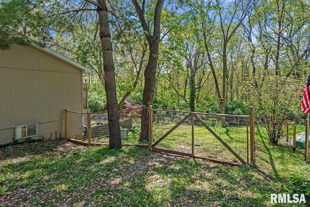 view of gate featuring a yard and fence
