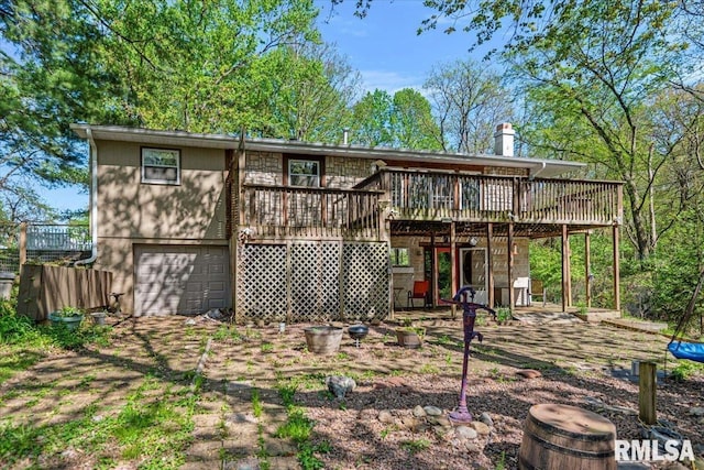 rear view of house with a wooden deck and an attached garage
