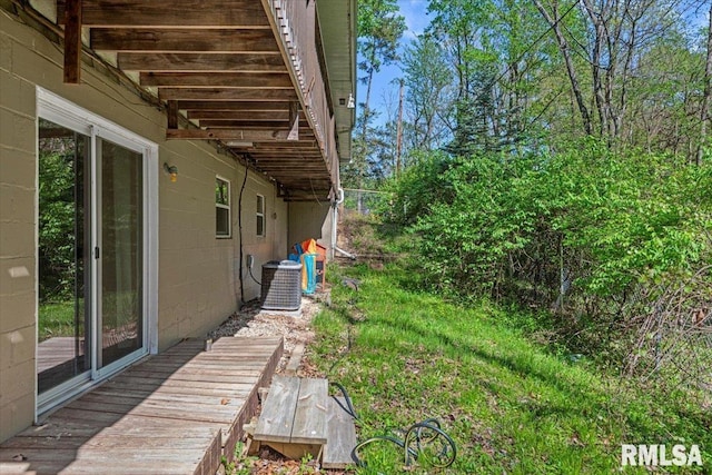 view of yard featuring cooling unit and a deck