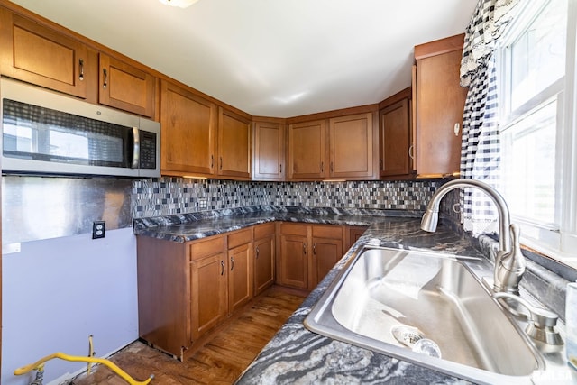 1620 N 703rd Ln, Liberty, IL 62347 - kitchen featuring brown cabinets, a sink, stainless steel microwave, and tasteful backsplash