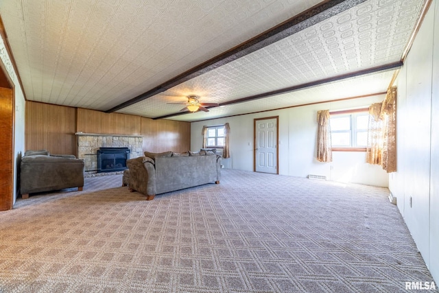 1620 N 703rd Ln, Liberty, IL 62347 - living room with beam ceiling, a glass covered fireplace, a ceiling fan, wooden walls, and carpet floors