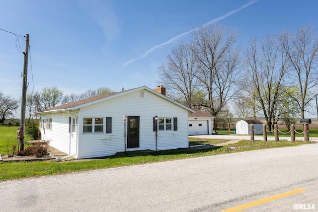 1620 N 703rd Ln, Liberty, IL 62347 - bungalow-style home with a chimney, driveway, an outbuilding, a detached garage, and a storage unit