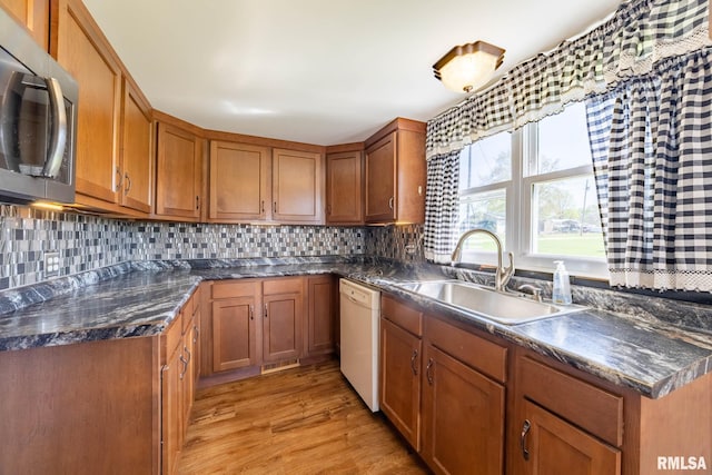 1620 N 703rd Ln, Liberty, IL 62347 - kitchen with brown cabinets, dishwasher, a sink, stainless steel microwave, and light wood-style floors