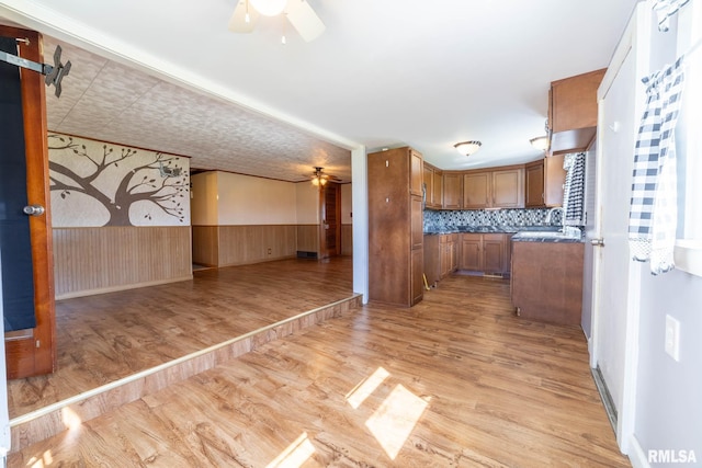 1620 N 703rd Ln, Liberty, IL 62347 - kitchen with a wainscoted wall, a ceiling fan, light wood-type flooring, brown cabinetry, and open floor plan