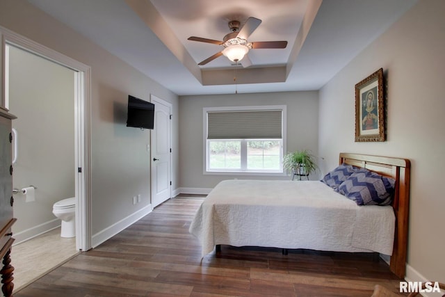 515 Gardendale Dr, Quincy, IL 62301 - bedroom with a tray ceiling, wood finished floors, connected bathroom, baseboards, and ceiling fan