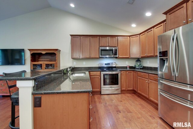 515 Gardendale Dr, Quincy, IL 62301 - kitchen with a sink, a breakfast bar area, light wood finished floors, lofted ceiling, and appliances with stainless steel finishes