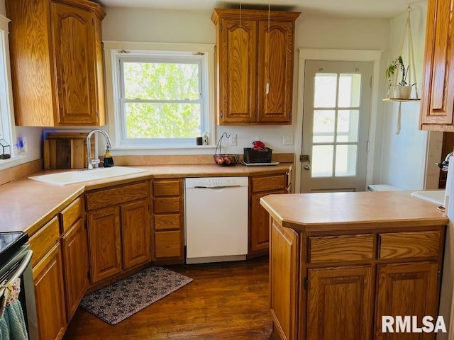 kitchen with stainless steel range with electric cooktop, brown cabinetry, white dishwasher, and a sink