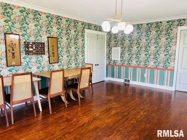 dining room featuring wallpapered walls, wood finished floors, visible vents, and ornamental molding
